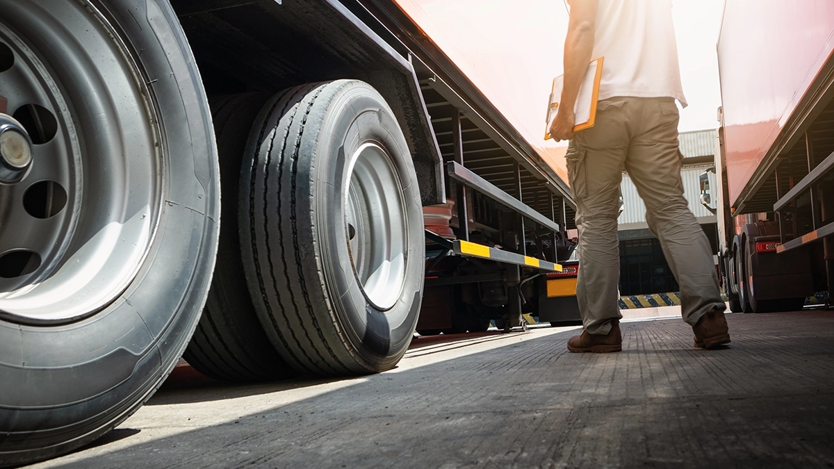 Truck driver inspecting a tractor trailer.