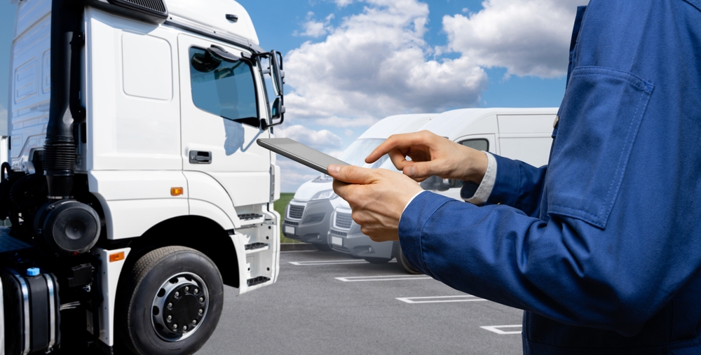 Fleet manager using a tablet for fleet management with trucks in the background