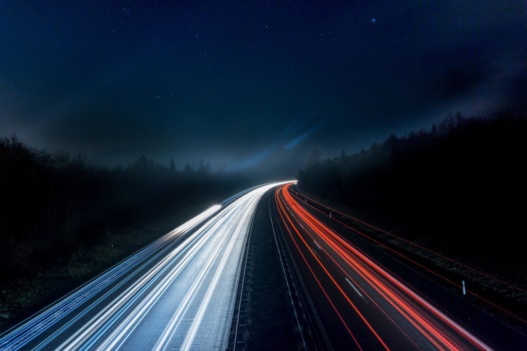 Light trails on a highway at night representing vehicle data flow and OBD-II telematics technology